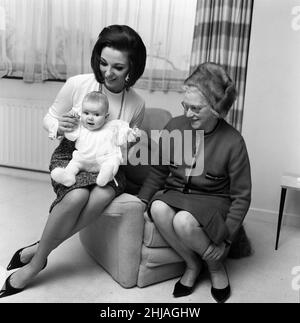 Joan Collins ha ritratto con la sua figlia di quattro mesi Tara Newley. Sono venuti a casa a Londra per vedere la famiglia. Qui sono oggi dopo che la mamma è stata negli studi cinematografici e il bambino Tara si è svegliato dopo il suo sonno. 20th febbraio 1964. Foto Stock