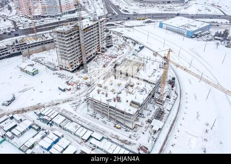 paesaggio urbano invernale con cantiere coperto di neve. vista aerea dall'alto. Foto Stock