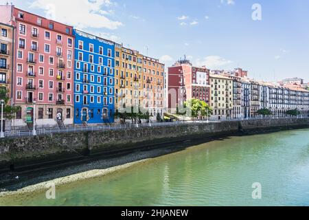 Bilbao, Spagna - Apr 16, 2021: Case colorate vicino al fiume Nervion nella città vecchia in giorno di sole. Iconico punto di riferimento della capitale Vizcaya Foto Stock