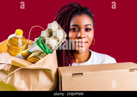 volontario ispanico americano che sostiene il concetto di donazione di cibo Foto Stock