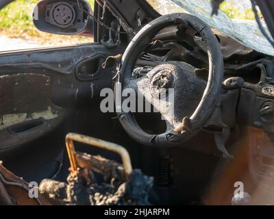 Resti di una vecchia macchina schiantata bruciata dall'interno Foto Stock