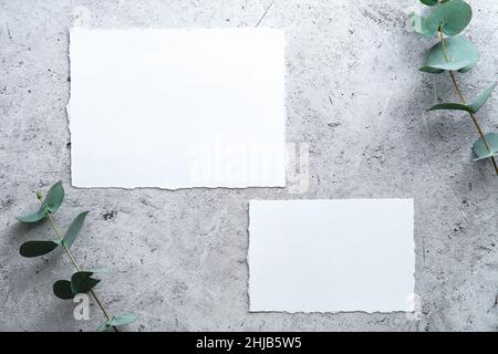 Matrimonio RSVP carte modelli con eucalipto su tavola in pietra vista dall'alto. Foto Stock