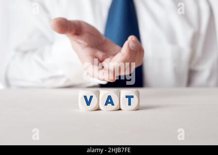 Businessperson mano che mostra l'acronimo iva valore aggiunto imposta scritto su cubi di legno. Foto Stock