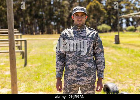 Ritratto del soldato caucasico in uniforme in piedi al campo di stivali Foto Stock