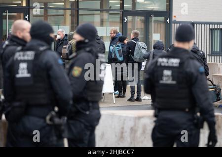 Dresda, Germania. 28th Jan 2022. I giornalisti attendono dietro gli ufficiali di polizia di fronte all'edificio del processo della Corte Regionale - una sala speciale della Corte Regionale superiore di Dresda - per l'ammissione. Più di due anni dopo il furto del gioiello dalla storica Green Vault di Dresda, inizia il processo di sei presunti autori. Credit: Kahnert/dpa-Zentralbild/dpa/Alamy Live News Foto Stock