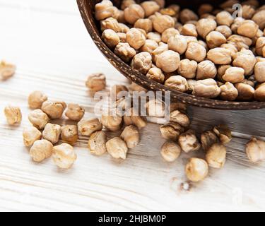 Ceci secchi non cotti in ciotola su un vecchio tavolo di legno Foto Stock