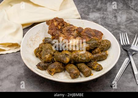 Confezionamento di foglie di carne. Sapore mediterraneo tradizionale. Avvolgimento foglie su sfondo scuro. Nome locale etli yaprak sarma Foto Stock