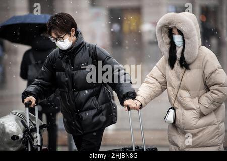 Wuhan, Cina. 28th Jan 2022. I passeggeri che indossano le maschere camminano nella nevicata alla stazione ferroviaria di Hankou a Wuhan.Un totale di 2,8 miliardi di viaggi passeggeri sono attesi durante i 40 giorni 'Chunyun, ' o Spring Festival corsa, che ha iniziato dal 17 gennaio di quest'anno. Milioni di cinesi si recheranno a casa per visitare le famiglie in massa durante il periodo di festa di Primavera che inizia con il Capodanno lunare il 1 febbraio. (Foto di Ren Yong/SOPA Images/Sipa USA) Credit: Sipa USA/Alamy Live News Foto Stock