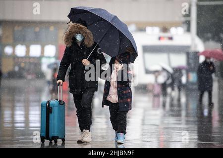 Wuhan, Cina. 28th Jan 2022. Una donna con il suo bambino a piedi nella nevicata alla stazione ferroviaria di Hankou a Wuhan.Un totale di 2,8 miliardi di viaggi passeggeri sono attesi durante i 40 giorni 'Chunyun, ' o corsa di viaggio Festival di primavera, che ha iniziato dal 17 gennaio di quest'anno. Milioni di cinesi si recheranno a casa per visitare le famiglie in massa durante il periodo di festa di Primavera che inizia con il Capodanno lunare il 1 febbraio. (Foto di Ren Yong/SOPA Images/Sipa USA) Credit: Sipa USA/Alamy Live News Foto Stock