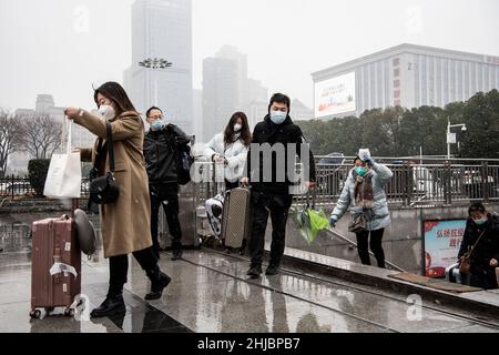 Wuhan, Cina. 28th Jan 2022. I passeggeri che indossano le maschere camminano nella nevicata alla stazione ferroviaria di Hankou a Wuhan.Un totale di 2,8 miliardi di viaggi passeggeri sono attesi durante i 40 giorni 'Chunyun, ' o Spring Festival corsa, che ha iniziato dal 17 gennaio di quest'anno. Milioni di cinesi si recheranno a casa per visitare le famiglie in massa durante il periodo di festa di Primavera che inizia con il Capodanno lunare il 1 febbraio. Credit: SOPA Images Limited/Alamy Live News Foto Stock