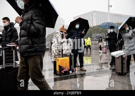 Wuhan, Cina. 28th Jan 2022. I passeggeri che indossano le maschere camminano nella nevicata alla stazione ferroviaria di Hankou a Wuhan.Un totale di 2,8 miliardi di viaggi passeggeri sono attesi durante i 40 giorni 'Chunyun, ' o Spring Festival corsa, che ha iniziato dal 17 gennaio di quest'anno. Milioni di cinesi si recheranno a casa per visitare le famiglie in massa durante il periodo di festa di Primavera che inizia con il Capodanno lunare il 1 febbraio. Credit: SOPA Images Limited/Alamy Live News Foto Stock