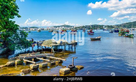 Paesaggi costieri con barche e uno skyline urbano in lontananza. La comunità di pescatori di Jurujuba fa parte della costa della baia di Guanabara a Nitreoi Foto Stock