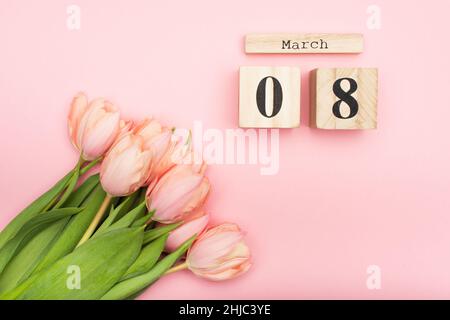 vista dall'alto dei tulipani vicino ai cubetti di legno con il 8 marzo su rosa Foto Stock