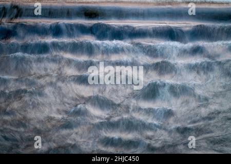 L'acqua in rapido movimento rotola a valle fotografata dal basso. Foto Stock