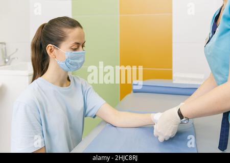 Un medico si è avvolto intorno al polso per primo soccorso. Applicazione di bende sulle mani del paziente, concetti di pronto soccorso e lesioni al polso Foto Stock