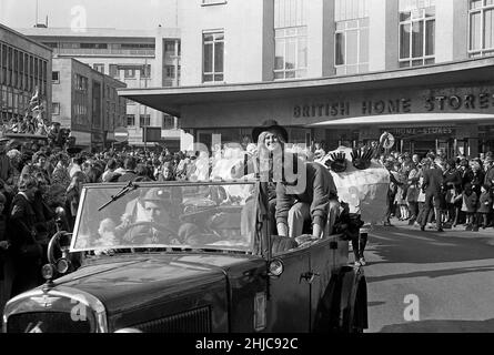 Il 1969 Rag Queen della Bristol University guida la processione della settimana per la raccolta di fondi in auto classiche all'aperto attraverso il centro di Bristol. Il 1930s Austin 12 ha guidato una sfilata di carri decorati da studenti che partì il 8 marzo dal parcheggio della stazione di Clifton e proseguì lungo Park Street fino a Baldwin Street, poi attraverso Broadmead, tornando lungo Lower e Upper Maudlin Street e Park Row. Migliaia di spettatori hanno fiancheggiato le strade e migliaia di sterline sono stati allevati per carità. I collezionisti di studenti possono essere visti in background con le persone che si raggiungono per contribuire. Foto Stock