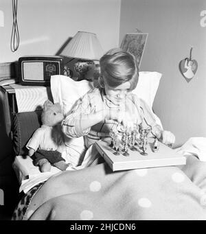 Giocattoli nel 1940s. Un ragazzo nel suo letto sta giocando con i soldati giocattolo. I giocattoli tedeschi sono realizzati da Elastolin e presenta soldati tedeschi in uniforme. Le cifre sono state popolari durante la guerra mondiale del 2 anche in altri paesi che non la Germania. Spesso con il simbolo nazista presente sulle bandiere e uniformi dei giocattoli. febbraio 1940 Kristoffersson Ref L79-3 Foto Stock