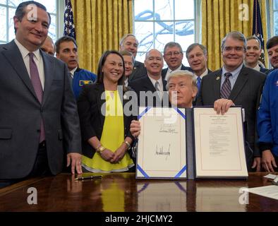 Il presidente Donald Trump presenta il firmato NASA Transition Authorization Act del 2017, affiancato dal senatore Ted Cruz (Texas), a sinistra, e da altri membri del Congresso. Foto Stock