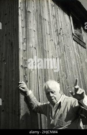 Il poeta del New England Robert Frost (1874 - 1963) si trova accanto a un fienile nella sua fattoria vicino a Ripton, Vermont. Famosa per poesie come "Spopping by Woods on a Snowy Evening" e "The Road Not Toked", Frost ha vinto quattro premi Pulitzer durante la sua vita. Foto Stock