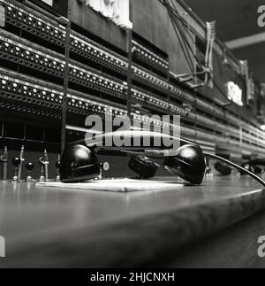 Telefonia nel 1970s. Interno da un locale vuoto con un grande centralino visibile. Tecnologia del passato che non è più in uso o il personale di esso non si è ancora seduto a lavorare ad esso. Si tratta di un centralino manuale in cui è necessario un operatore umano per collegare le chiamate manualmente. Svezia 1971 Kristoffersson Ref ed Foto Stock