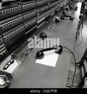 Telefonia nel 1970s. Interno da un locale vuoto con un grande centralino visibile. Tecnologia del passato che non è più in uso o il personale di esso non si è ancora seduto a lavorare ad esso. Si tratta di un centralino manuale in cui è necessario un operatore umano per collegare le chiamate manualmente. Svezia 1971 Kristoffersson Ref ed Foto Stock