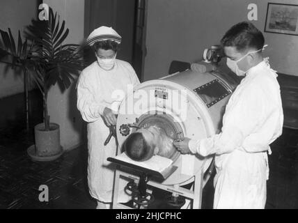 Un ragazzo in un polmone di ferro ad un ospedale navale, c. 1960. Foto Stock