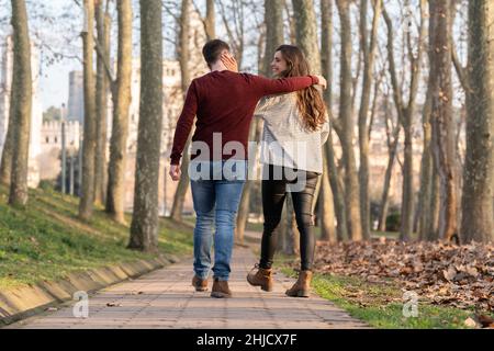 Giovane coppia uomo e donna che cammina e abbraccia in un parco il giorno di San Valentino Foto Stock