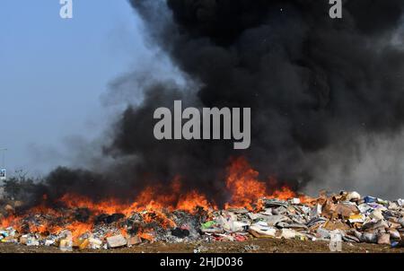 Lahore, Pakistan. 26th Jan 2022. I funzionari doganali pakistani bruciano per distruggere le merci contrabbandate (sigarette, tabacco da masticare, noci di Betel, fuochi d'artificio e altre cose vicino al confine di Wagha alla vigilia della giornata doganale mondiale a Lahore, Pakistan, il 26 gennaio 2022. Un pile di farmaci confiscati, sigarette e altri beni sequestrati da diverse aree, durante la cerimonia di lancio di campagne di sensibilizzazione in tutta la provincia, organizzato dalla dogana pakistana tenutasi al confine di Wagha a Lahore (Foto di Rana Sajid Hussain/Pacific Press/Sipa USA) Credit: Sipa USA/Alamy Live News Foto Stock