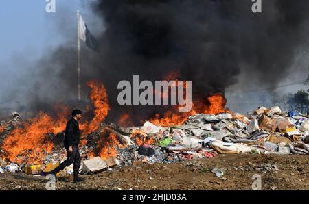 Lahore, Pakistan. 26th Jan 2022. I funzionari doganali pakistani bruciano per distruggere le merci contrabbandate (sigarette, tabacco da masticare, noci di Betel, fuochi d'artificio e altre cose vicino al confine di Wagha alla vigilia della giornata doganale mondiale a Lahore, Pakistan, il 26 gennaio 2022. Un pile di farmaci confiscati, sigarette e altri beni sequestrati da diverse aree, durante la cerimonia di lancio di campagne di sensibilizzazione in tutta la provincia, organizzato dalla dogana pakistana tenutasi al confine di Wagha a Lahore (Foto di Rana Sajid Hussain/Pacific Press/Sipa USA) Credit: Sipa USA/Alamy Live News Foto Stock