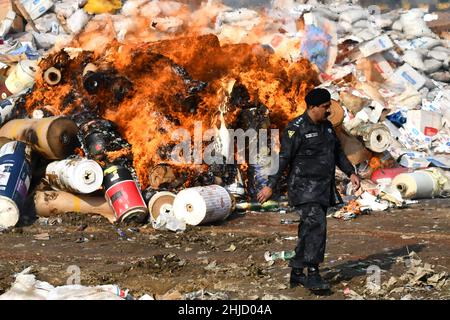 Lahore, Pakistan. 26th Jan 2022. I funzionari doganali pakistani bruciano per distruggere le merci contrabbandate (sigarette, tabacco da masticare, noci di Betel, fuochi d'artificio e altre cose vicino al confine di Wagha alla vigilia della giornata doganale mondiale a Lahore, Pakistan, il 26 gennaio 2022. Un pile di farmaci confiscati, sigarette e altri beni sequestrati da diverse aree, durante la cerimonia di lancio di campagne di sensibilizzazione in tutta la provincia, organizzato dalla dogana pakistana tenutasi al confine di Wagha a Lahore (Foto di Rana Sajid Hussain/Pacific Press/Sipa USA) Credit: Sipa USA/Alamy Live News Foto Stock