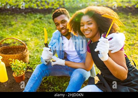 famiglia brasiliana che raccoglie o piantando un raccolto in primavera giorno di sole all'aperto Foto Stock