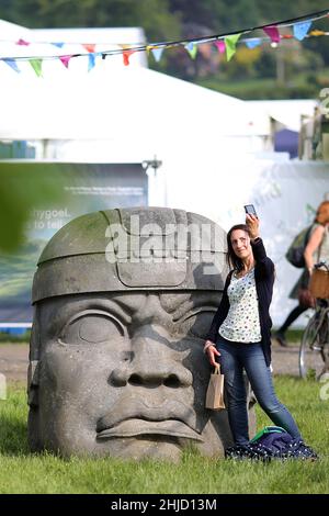 Hay Festival, una donna prende un selfie con una scultura enorme di un haed messicano, a Hay-on-Wye, Powys, Galles il 26th maggio 2018. Foto Stock