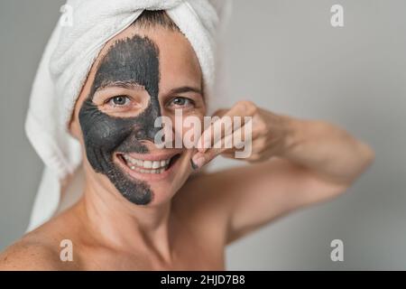 Felice donna matura che ha cura della pelle giornata termale - persone stile di vita benessere concetto Foto Stock
