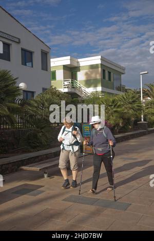 I turisti più anziani camminano lungo la passeggiata costiera a Playa de los Ingleses, Maspalomas, Gran Canaria, Spagna Foto Stock