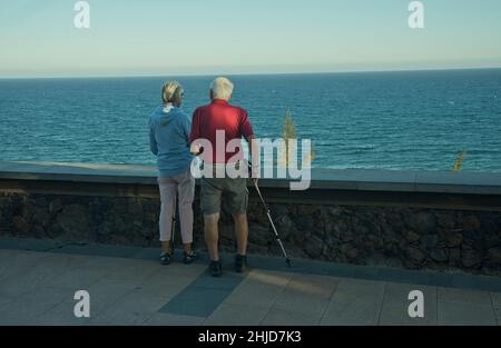 I turisti più anziani camminano lungo la passeggiata costiera a Playa de los Ingleses, Maspalomas, Gran Canaria, Spagna Foto Stock