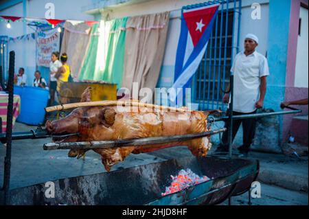 Lo chef cubano cuoca un grande porto per barbecue ad una festa di strada e fiesta a Las Tunas, Cuba. Foto Stock