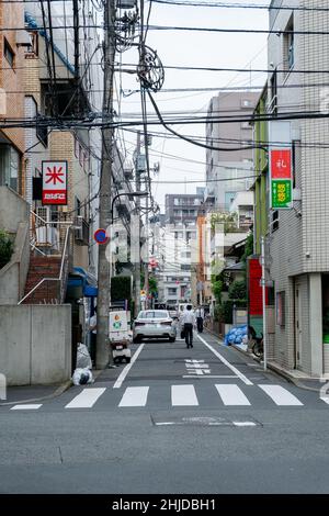 Vista di vicolo stretto al mattino nella zona residenziale di Ikebukuro, Toshima, Tokyo con lampioni e segnaletica stradale Foto Stock