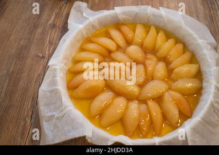 Pera tatin crostata prima di cucinare. Vista dall'alto su un tavolo di legno. Foto Stock