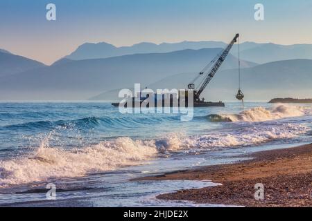 Scavatore di mare che regola la costa di ciottoli. Foto Stock