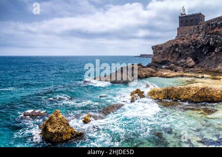 Faro nel porto di Melilla, provincia spagnola in Marocco. La costa rocciosa del Mar Mediterraneo. Foto Stock