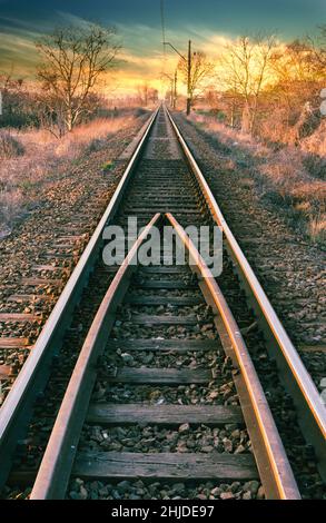 Linea ferroviaria direttamente al bellissimo tramonto Foto Stock