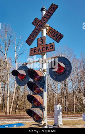 Vintage, vecchio, antico tre binari lampeggiante luce traversa segnale di avvertimento nel cuore del Dixie Railroad Museum a Calera Alabama, USA. Foto Stock