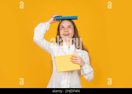 la ragazza teen fa i compiti con copybook. studio con libro di lavoro. stupito libro di tenuta del bambino. Foto Stock