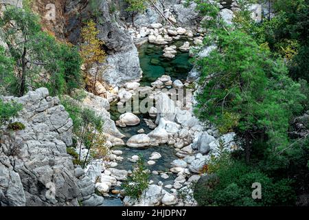 canyon boscoso di montagna con un chiaro ruscello blu in un letto roccioso, vista dall'alto Foto Stock