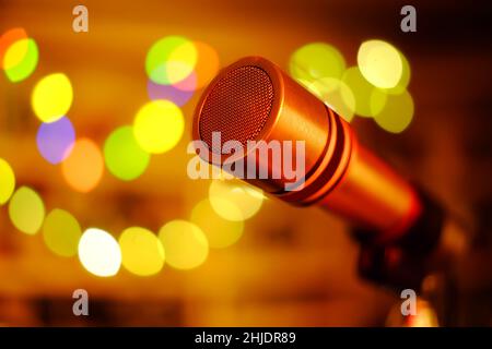 Microfono vintage sul palco con luce bokeh, bar Karoke, intrattenimento, concetto musicale, primo piano con palline bokeh, spazio di copia buono. Foto Stock