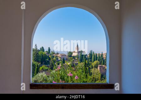 L'alhambra attraverso la finestra ad arco dai giardini del generalife a granada, spagna Foto Stock