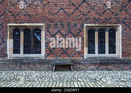 Finestre Tudor casement & mattoni policromi Tudor: Mattoni rossi-arancioni in English Cross-bond. Cantiere di ciottoli. Hampton Court Palace, Londra Foto Stock