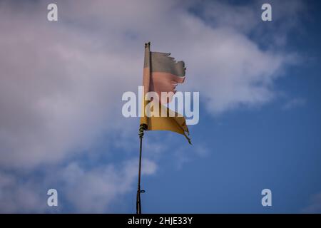 Una bandiera tedesca lacerata con nuvole sullo sfondo, vista vicino Klein Kubitz, Meclemburgo-Pomerania occidentale, Germania Foto Stock