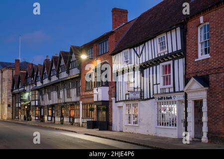 Legno incorniciato e mattoni edifici lungo la strada cappella al crepuscolo. Stratford upon Avon, Warwickshire, Inghilterra Foto Stock