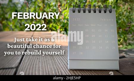Calendario azzurro di febbraio 2022 su sfondo verde con citazione motivazionale. Concetto motivazionale. Foto Stock